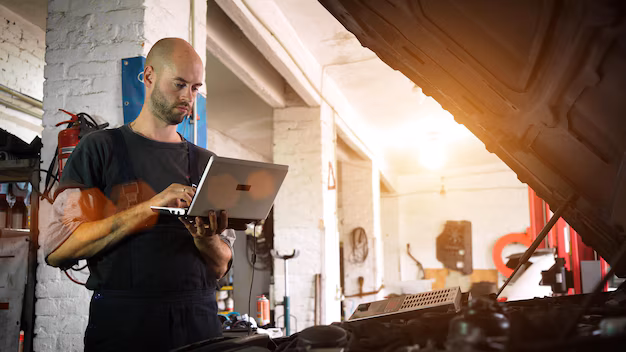 Mechanic using a laptop for diagnosing vehicle issues